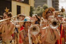 Bunt kostümierte Bläsergruppe spielt bei einem Freiluftfestival