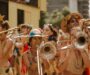 Bunt kostümierte Bläsergruppe spielt bei einem Freiluftfestival