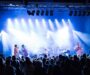 Open-Air-Konzert mit Band, blauem Licht und dichtem Publikum