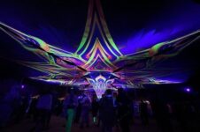 Leuchtende psychedelische Lichtkunst-Installation über tanzenden Festivalbesuchern